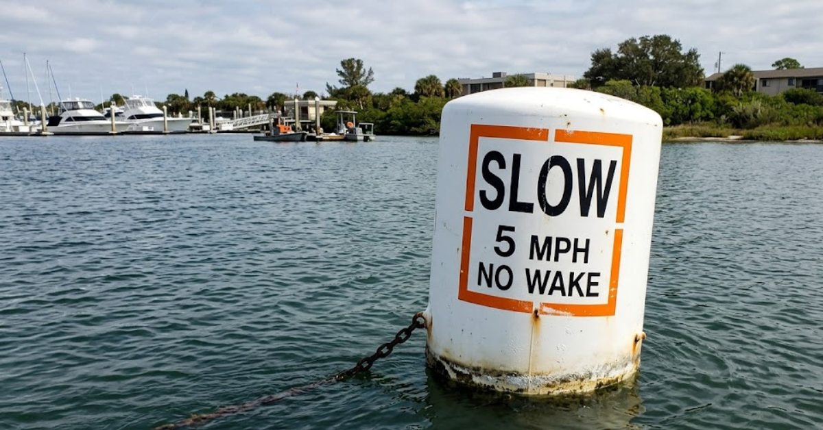 You see a white buoy with an orange square and black lettering: what does this buoy tell you?